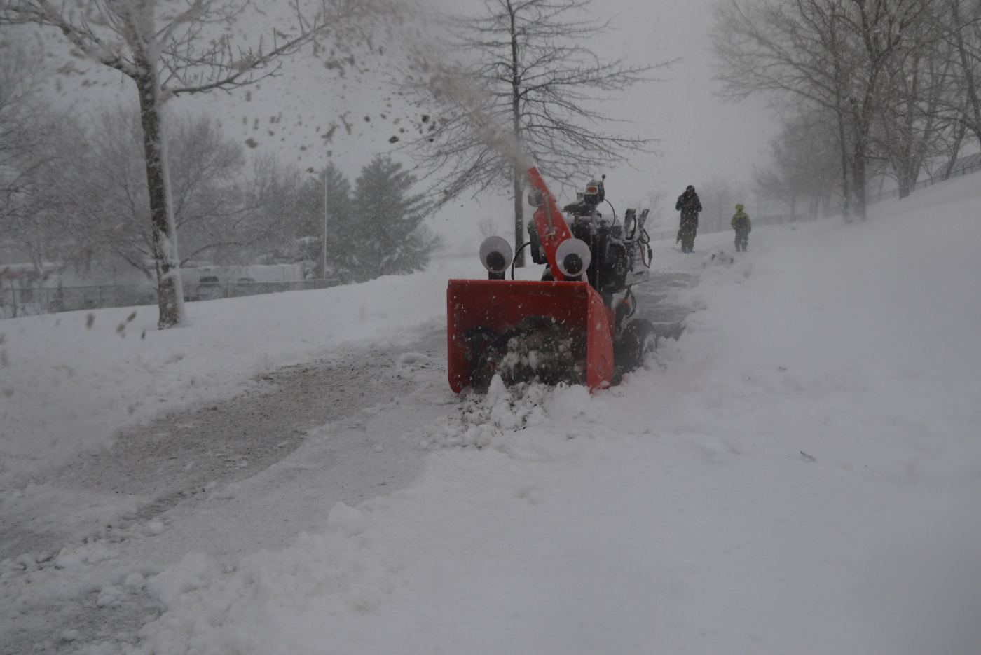 Autonomous Snowblower in Action on a Sidewalk in a Park.